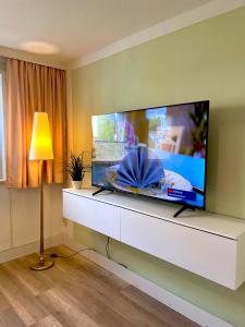 sala de estar con TV de pantalla plana grande en la pared en FeWo Sunshine en Heringsdorf