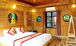 a bedroom with two beds in a room with wooden walls at Tam Coc Amanda Villas in Ninh Binh