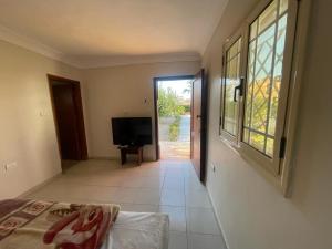 a room with a bed and a window and a television at Moubark 6 Studio in Hurghada