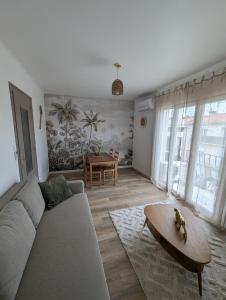 een woonkamer met een bank en een tafel bij L'exotic' 1 à 4 voyageurs in Perpignan