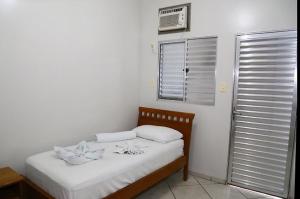 Dormitorio pequeño con cama y aire acondicionado en SWAMY HOTEL ANEXO I, en Cruzeiro do Sul