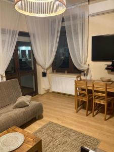 ein Wohnzimmer mit einem Sofa und einem Tisch in der Unterkunft Apartament Comfort Kahlberg in Krynica Morska