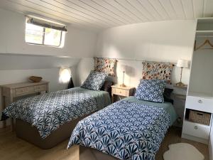 een kleine slaapkamer met 2 bedden en een raam bij Péniche GEMJO in Castelsarrasin