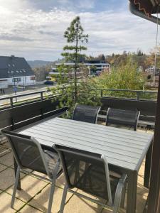 a wooden table and chairs on a roof at Ferienwohnung Heidi Winterberg in Winterberg