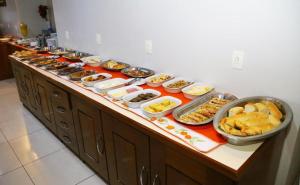 a buffet line with many different types of food at SWAMY HOTEL ANEXO I in Cruzeiro do Sul