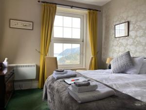 a bedroom with a bed and a window with yellow curtains at Sinai House in Lynton