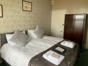 Una cama con dos toallas y una bandeja. en Sinai House, en Lynton