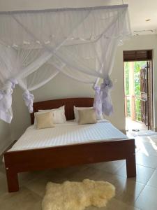 a bedroom with a bed with a canopy at Golden Cherries Guest House in Jinja