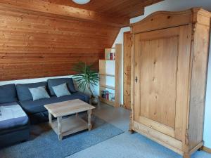 uma sala de estar com um sofá azul e uma parede de madeira em Dachgeschosswohnung mit Burgblick in Kues em Bernkastel-Kues