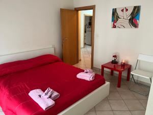 een slaapkamer met een rood bed en een tafel bij Villetta Audrey al Mare in Riccione