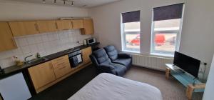 a small kitchen with a couch and a chair in a room at SELF CHECK IN APARTMENT DONCASTER in Doncaster