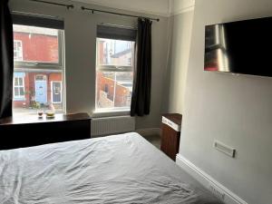 um quarto com uma cama e uma grande janela em Stay in the heart of West Kirby em West Kirby