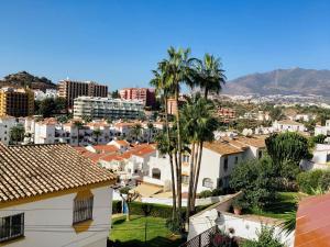 uitzicht op een stad met palmbomen en gebouwen bij Casa Carlos in Benalmádena