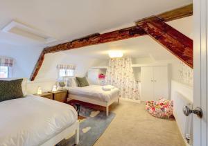 a bedroom with two beds and a window at Dulcima Cottage in Corfe Mullen