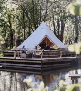a white tent on a dock in the water at POLE POLE - Ijsbeer in Lichtaart