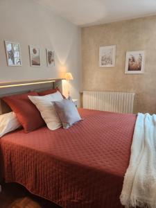 - une chambre avec un lit doté de draps et d'oreillers rouges dans l'établissement Chambres d'hotes Le Bernes, à Vic-Fezensac