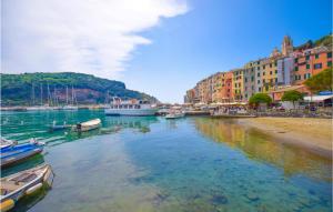 a group of boats in a river next to buildings at Cozy Apartment In Le Grazie With Kitchen in Le Grazie