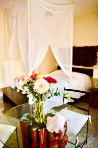 a room with a table with a vase of flowers at Hotel Delfin in Playa del Carmen