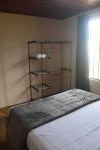 een slaapkamer met een bed en een plank aan de muur bij Casa Heliconia- La Fortuna in Fortuna