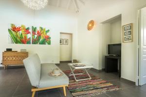 a living room with a chair and a table at Villa Kokomo - St. Francis, completely renovated in Saint-François