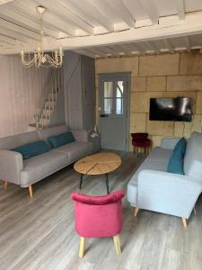 a living room with couches and a table at Gîte Mac Arthur in Bulson