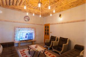 a living room with a couch and chairs and a tv at Harmony Houses Cappadocia in Ortahisar