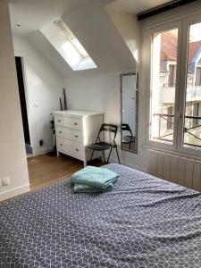 Schlafzimmer mit einem Bett, einem Schreibtisch und einem Fenster in der Unterkunft Appartement Saint Germain en Laye in Saint-Germain-en-Laye