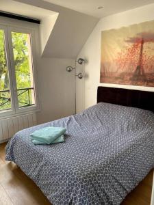 1 dormitorio con 1 cama y una pintura en la pared en Appartement Saint Germain en Laye en Saint-Germain-en-Laye