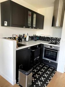 a kitchen with a black and white patterned floor at Appartement Saint Germain en Laye in Saint-Germain-en-Laye
