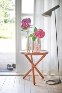 a table with two vases and flowers on it at HAUS ZWEINEUN in Brodersby