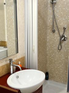 een badkamer met een witte wastafel en een douche bij ***** La casa di Giò in Caltanissetta