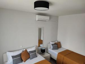 Habitación pequeña con 2 camas y espejo. en Apartments Benic en Neviđane