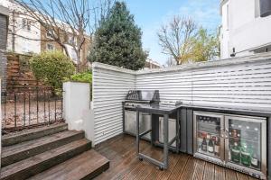 a barbecue grill on a deck in a backyard at Stylish Apartment with BBQ Kensington in London