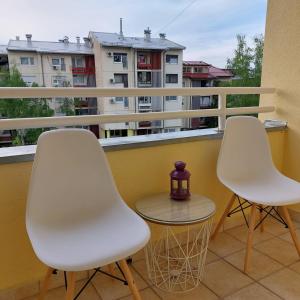 two white chairs and a table on a balcony at Apartman Divine in Banja Luka