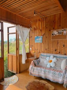 a bedroom with a bed and a large window at Nguyên căn - Góc sân và Khoảng trời Dalat Homestay in Ấp Phước Thánh