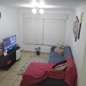 een woonkamer met een bank en een flatscreen-tv bij Apartamento BREÑA in Lima