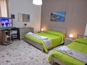 a hotel room with two beds and a television at Residenza Margherita - Centralissima in Salerno