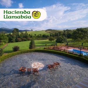 a stone patio with two chairs and a pool at Hotel Hacienda Llamabua in Navia