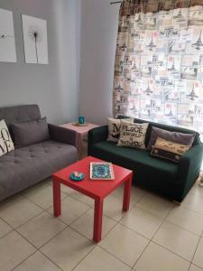 a living room with two couches and a red table at Wabi Sabi house in Ierápetra