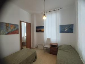 een kleine slaapkamer met 2 bedden en een raam bij Zornica Guest House in Chepelare