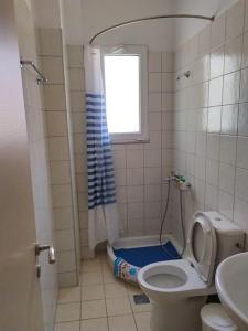 a bathroom with a toilet and a shower with a window at Wabi Sabi house in Ierápetra