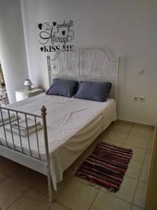 a bedroom with a white bed with blue pillows at Wabi Sabi house in Ierápetra