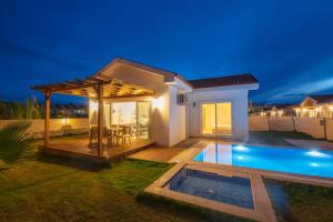 a villa with a swimming pool at night at SunTeos Villa Suites in Fethiye