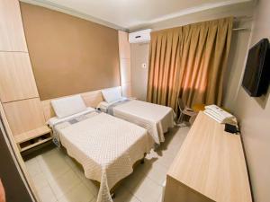 Habitación hospitalaria con 2 camas y TV en Hotel Pequeno Principe, en Arapiraca