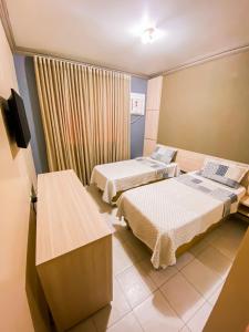 Zimmer mit 2 Betten und einem TV. in der Unterkunft Hotel Pequeno Principe in Arapiraca