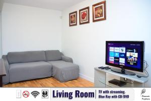 uma sala de estar com um sofá e uma televisão de ecrã plano em Stylish Guest Suite with Free Parking - Sleep up to 6 em Surrey