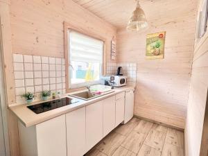 a small kitchen with a sink and a microwave at Domki Kapitana in Bobolin