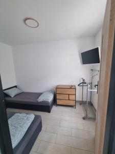 a room with two beds and a dresser and a tv at Apartament Nova Kamienica 3 in Łagów