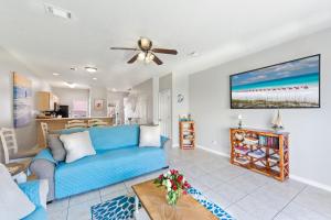 a living room with a blue couch and a table at Beach House 5min walk to beach, pool, close to shops and activities in Destin