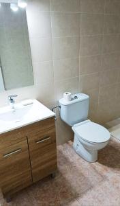 een badkamer met een toilet, een wastafel en een spiegel bij Menorca Cala Galdana in Cala Galdana